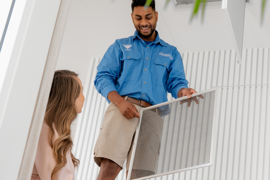 Talking to a customer while working on air-conditioner